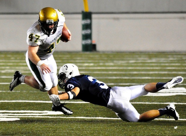 Auburn's Jacob Waldo runs hard with the ball as Bellarmine's Garrett McKay dives to make the tackle.