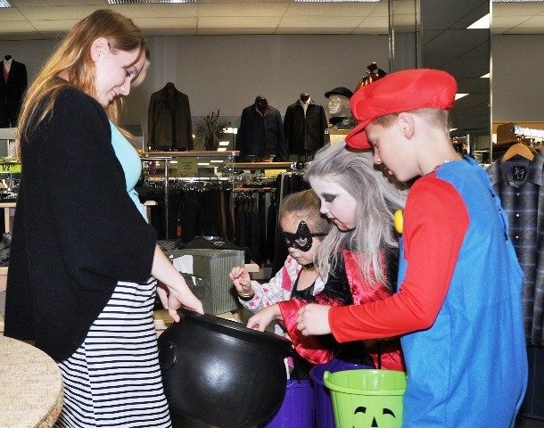 Employee Colleen Deputy gives out candy to trick-or-treaters at Rottles on Saturday.