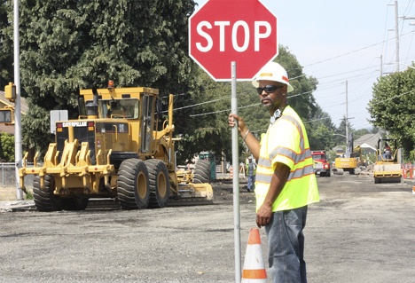 Joe Whitcomb flags traffic around the detour at M Street Northeast where it changes to Harvey Road.