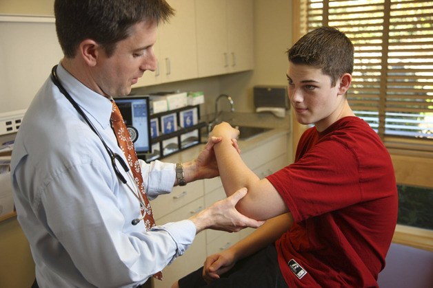 Dr. Jason Brayley works with a patient at his clinic at MultiCare Orthopedics & Sports Medicine in Puyallup.