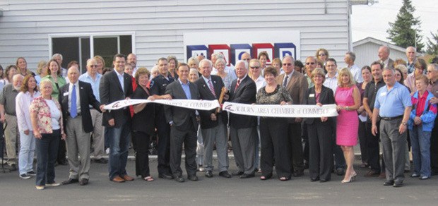 Auburn city officials and other dignitaries cut the ribbon at the opening of ACAP's new location.