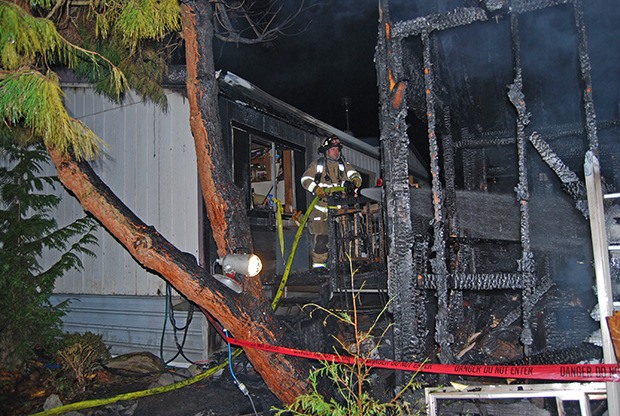 VRFA firefighters sift through a shed damaged by fire Friday afternoon in the Skylark Village II Mobile Park.