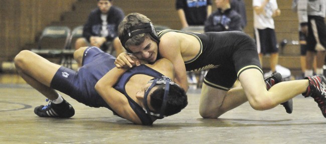 Auburn's 120-pounder Cameron Hiller notches a 12-10 decision over Rogers' Jose Cruz.