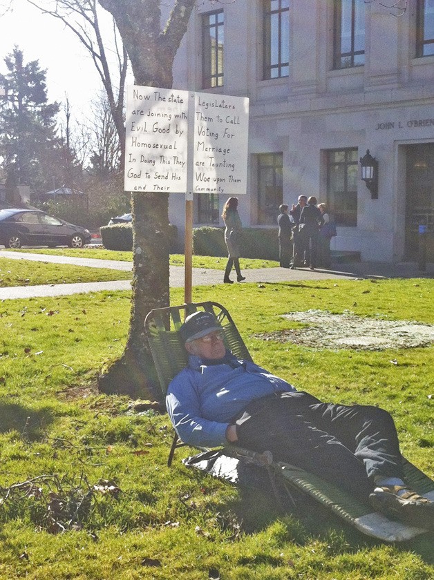 Longview's Jim Sathre represented a one-man protest against the Legislature's march toward approving a marriage equality bill on Monday. Sathre appears in the plaza between the House and Senate office buildings in Olympia during a hearing on the measure.