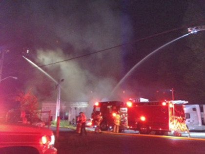 Crews work to extinguish a fire that severely damaged a body shop on Academy Drive Southeast Thursday night.