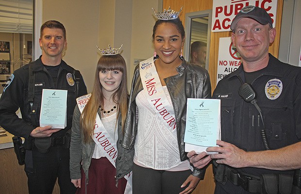 Miss Auburn's Morgan Warren and Miss Auburn's Outstanding Teen Keely Franchini present good bags of appreciation to Auburn Officers Mike McNabb