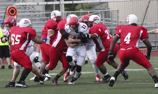 The South King County Colts defense stops Yakima Maverick quarterback John Lobbestael during the Colts' 21-14 overtime playoff victory over Yakima.