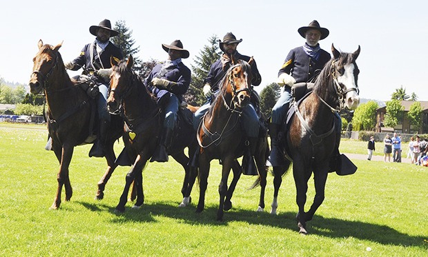 Members of the Buffalo Soldiers roam the playground field outside Cascade Middle School during the group’s visit Tuesday. The soldiers were invited to a school assembly to discuss the soldiers’ role in American history – from their inception during the Civil War to their service throughout the late 19th and early 20th century. Students learned about the service and dedication of African-American soldiers and their legacy to the country. The soldiers also demonstrated maneuvers and skills on horseback.