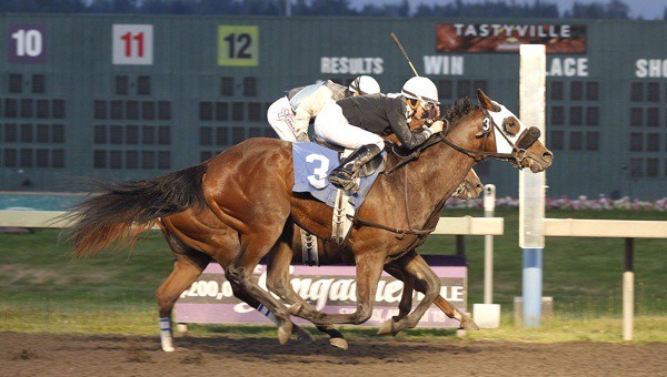 Risky Road (No. 3) and jockey Anne Sanguinetti edge Improviso by a head in the Friday feature race at Emerald Downs.