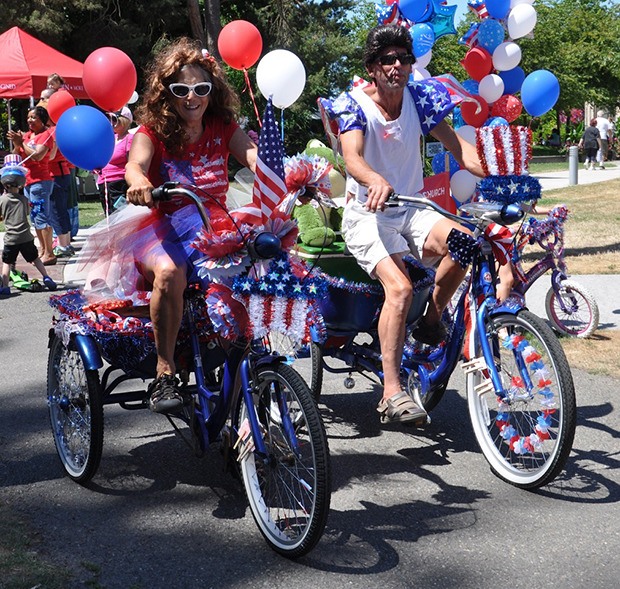 Gary Hopkins and Linda Madeo show their spirit during the bike parade at the Fourth of July Festival at Les Gove Park.