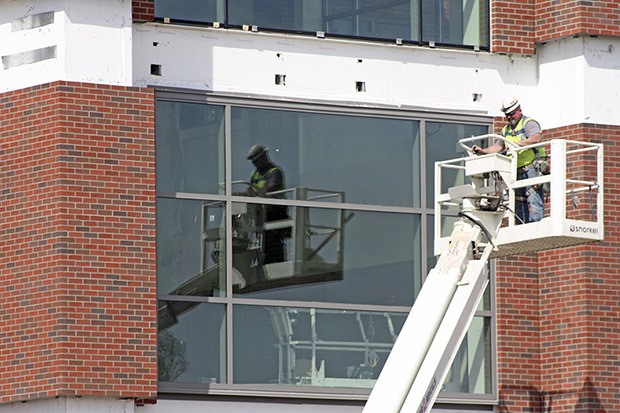 A construction crewman maneuvers in the 85-degree heat on May 1 as work continues on the construction of the new Auburn High School.