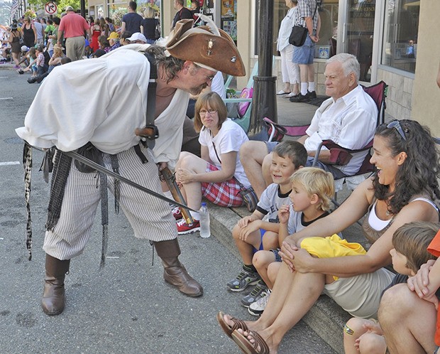 A Treasure Island Pirate greets the crowd assembled along Main Street during last year's Auburn Days grand parade. The parade returns Saturday.