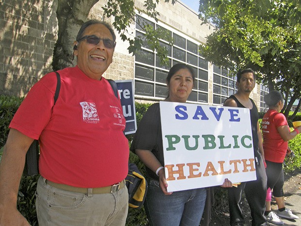 Dozens of  sign wavers and petition gatherers protested the potential closure of the King County Public Health Center in Auburn during an August rally.