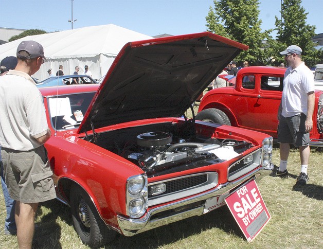 Car enthusiasts look over a classic Pontiac GTO during the recent Goodguys  Pacific Northwest Nationals at the Puyallup Fair & Events Center.