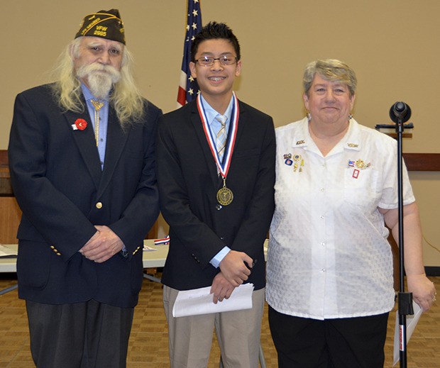 Skyler Verzosa accepts his first-place award from Jim Weaver