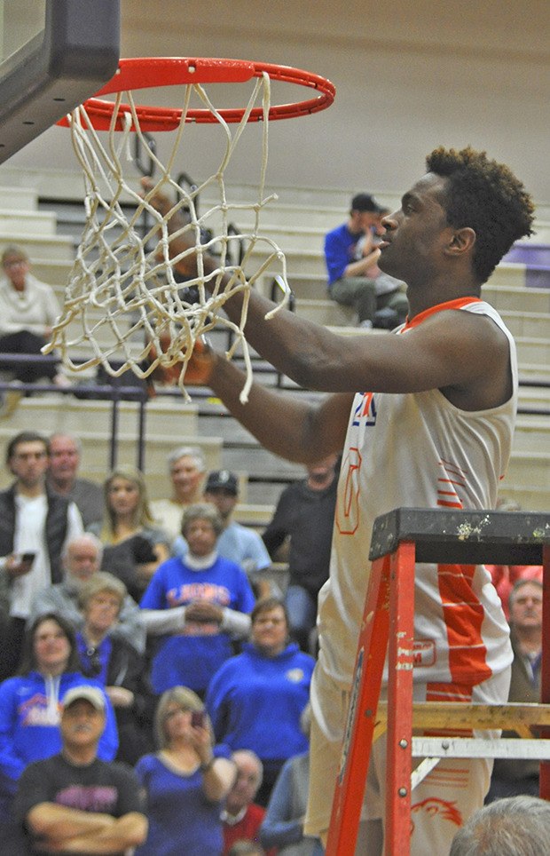 Ki’Jan Weisinger helps cut down the net after Auburn Mountainview's district title game victory over Enumclaw.