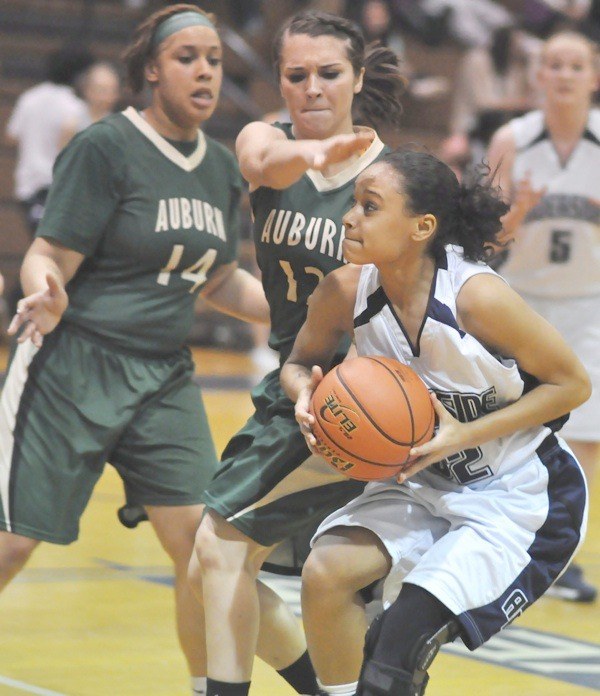 Raven Kendall Foster fends off Auburn defenders Taryn Papillon (No. 14) and Becci Galati (No. 12).