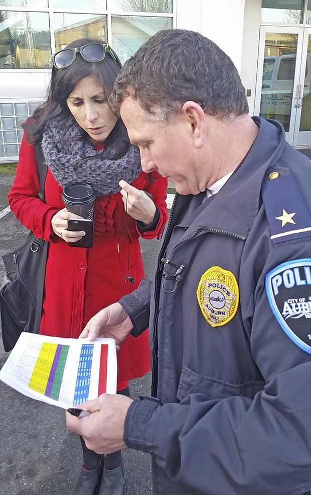 Auburn Police Cmdr. Mike Hirman goes over some data with a reporter during a Thursday news conference at police headquarters. Police arrested a man tied to a series of arsons.