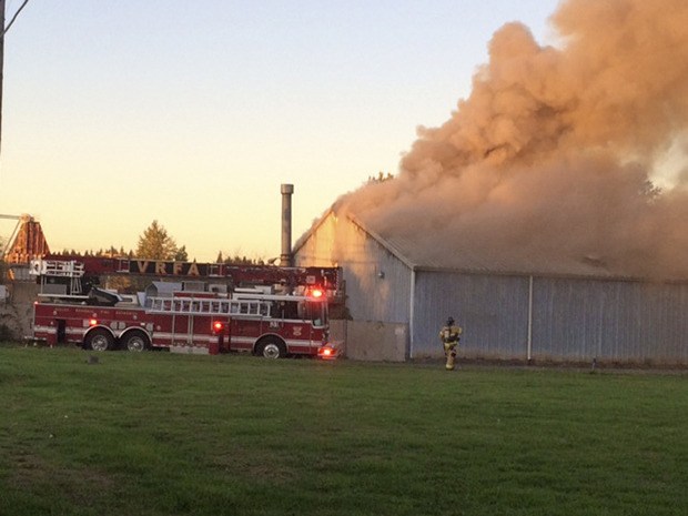 Firefighters contend with a large warehouse fire at 2809 Academy Drive SE on Tuesday evening. The fire destroyed the building. No one was hurt in the blaze.