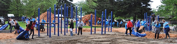 Volunteers work to put in a new playground at Isaac Evans Park. The city received a $15