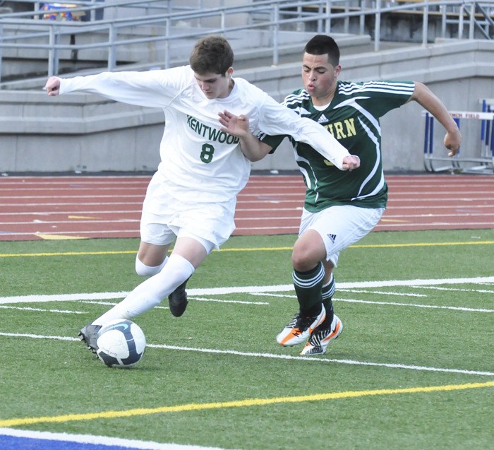 Kentwood's Hunter Pyne fends off Auburn defender Anthony Pennington.