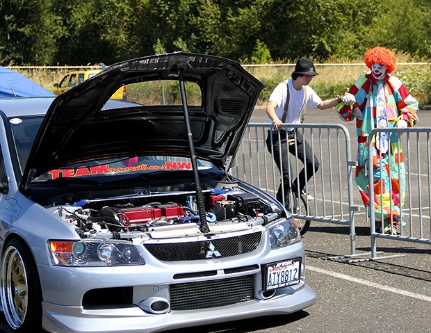 Deano The Clown helps a spectator balance on a unicycle during this past Saturday's Unity Custom Car Show at the White River Amphitheatre in Auburn. The event – sponsored by the Muckleshoot Tribe and One Reel Productions – featured several custom hot rods