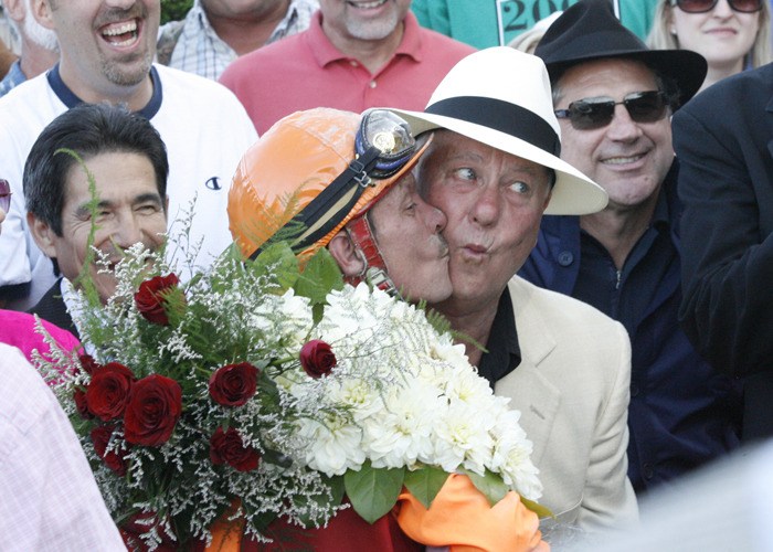 Lou Tice gets a kiss from jockey Gallyn Mitchell after Assessment's win in the Longacres Mile in 2009.