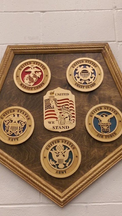 A wooden plaque – featuring all five U.S. Military Branch of Service Seals – hangs on the front wall at Lowe’s in Auburn.