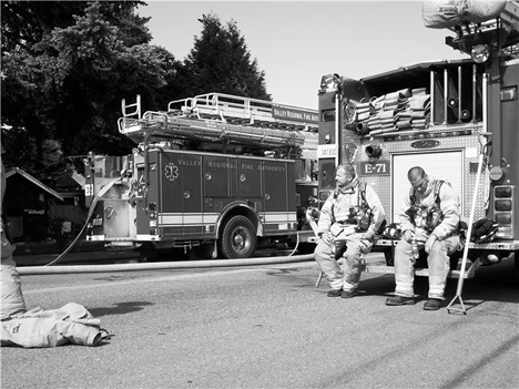 Valley Regional Firefighters rest after containing a residential fire in the 300 block of D Street Southeast in Auburn on June 4. Nick Wilson