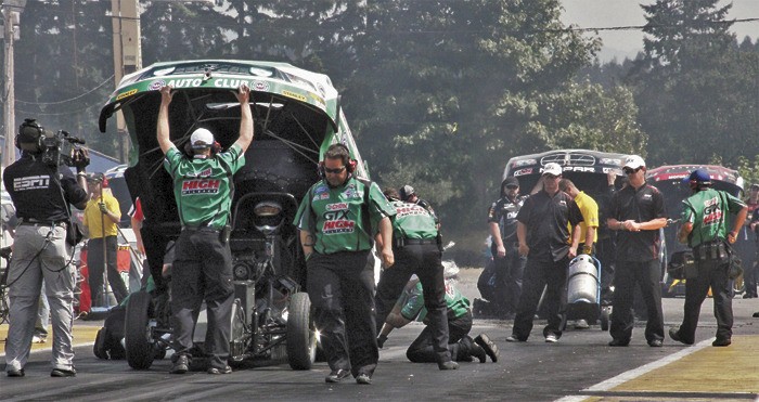 John Force's Top Fuel funny car leads the lineup at the starting line at Pacific Raceways.