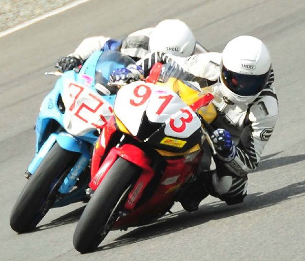 Novice class motorcycle racers push their machines on the track at Pacific Raceways.