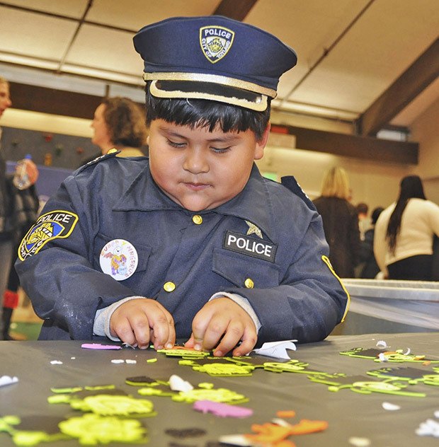 Police chief Euben Lagunas solves a clue to a puzzle during last year's Halloween Harvest Festival at Washington Elementary School.