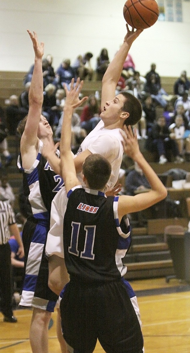 Auburn Riverside's Bridger Harlington shoots over two Auburn Mountainview defenders.