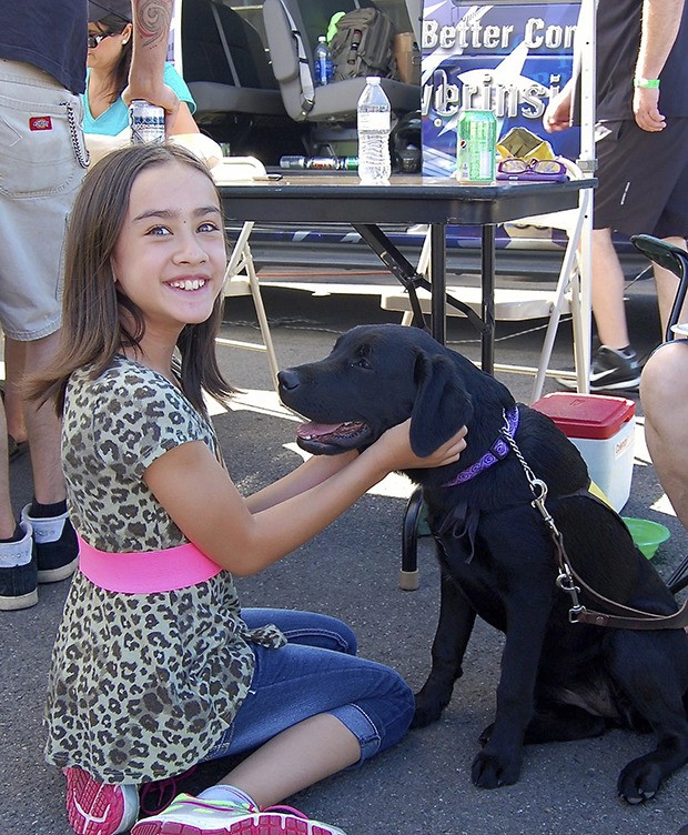 A girl attending the Machinists Union Local Lodge 751-F’s annual Karting Challenge at PGP Motorsports Park in Kent greets a Guide Dogs of America puppy-in-training. The union raised $322