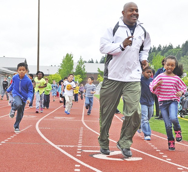 Former Seahawk Nesby Glasgow leads Ilalko Elementary students around the track at Auburn Riverside High School during Ilalko’s 18th annual fun run last Friday. The run promotes the importance of health and fitness in the community. Seahawks mascot Blitz also was on hand to encourage kids. Teachers