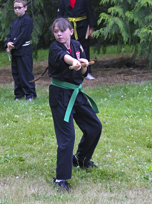 AKEA student Stormy Byrd demonstrates her bo skills during the Auburn dojo's advancement ceremony.