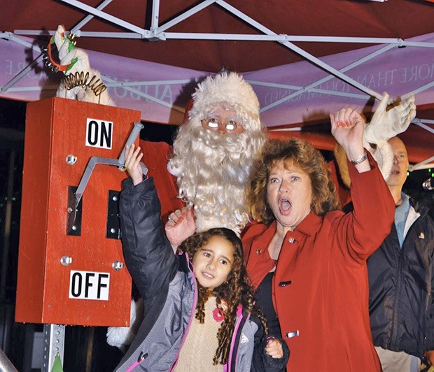 Mayor Nancy Backus joins Stefany Sanchez and Santa to turn on the switch