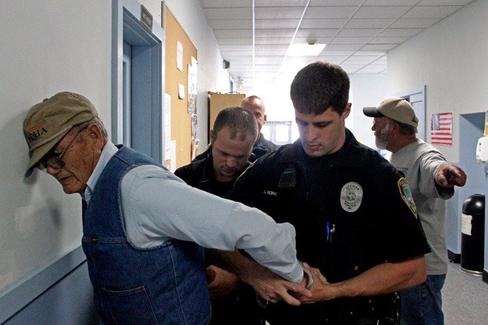 Pacific Police officers place handcuffs on Mayor Cy Sun after he tried to enter the sealed City Clerk's office at City Hall on Thursday.