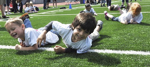 Preschoolers from Gildo Rey Elementary School do the snake walk at Auburn Memorial Stadium during Young Athletes Day on Monday.