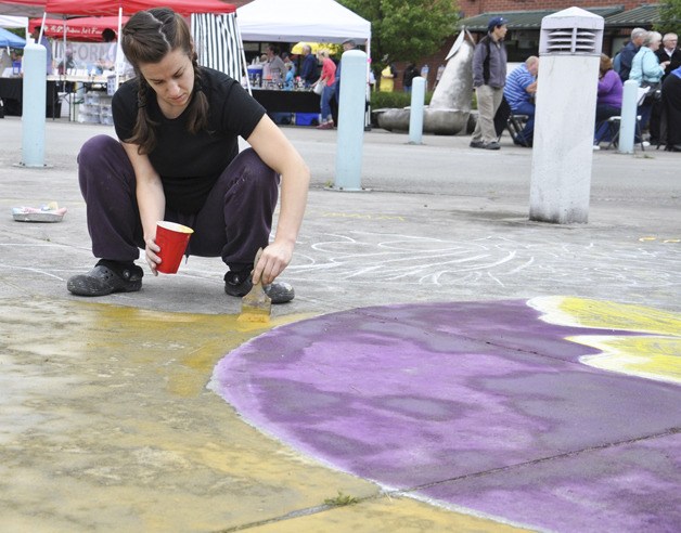 Gabrielle Abbott paints the summer solstice at the opening of the Auburn International Farmers Market last Sunday. The market is open on Sundays throughout the summer.