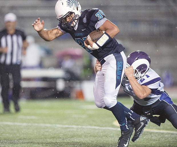 Auburn Riverside’s Sam Braboy tries to escape the grasp of North Thurston’s Zion Kirk during season-opening