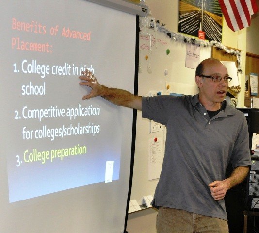 Auburn Riverside High School teacher Tim Wright describes advanced placement classes to visitors at the Reaching Out Fair on Thursday.