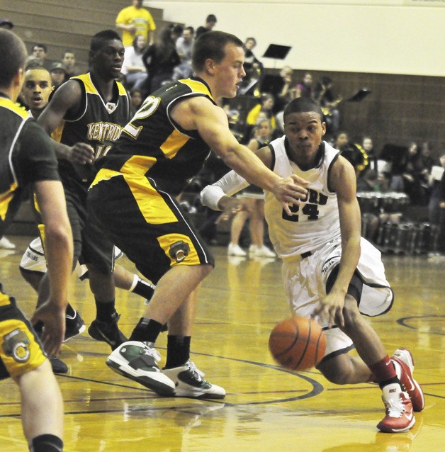 Auburn's Kevin Henderson drives on Kentridge's Caleb Smith during SPSL action Tuesday. Henderson scored 26 points in the Trojans' win.