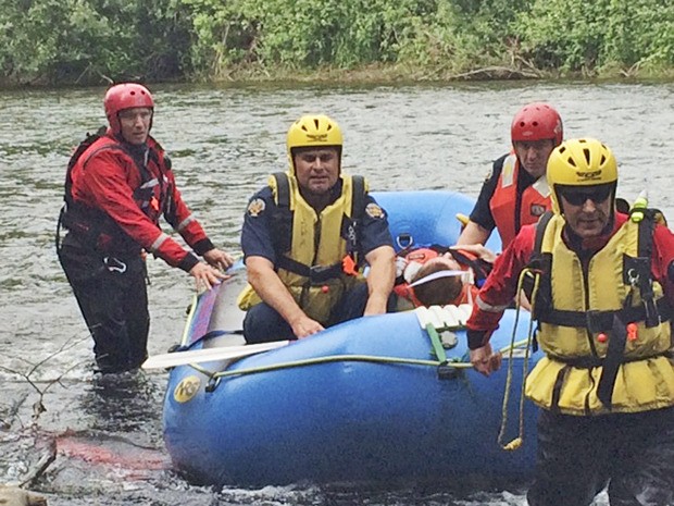 Firefighters transport an injured man off the banks of the Green River on Tuesday afternoon. The man was transported to MultiCare Auburn Medical Center with non-life-threatening injuries.