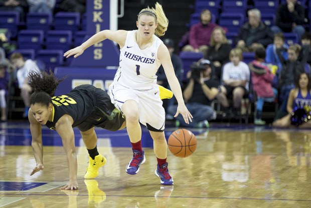 The Huskies' Mercedes Wetmore pushes the ball up the floor as the Ducks' Ariel Thomas tumbles. Washington beat Oregon