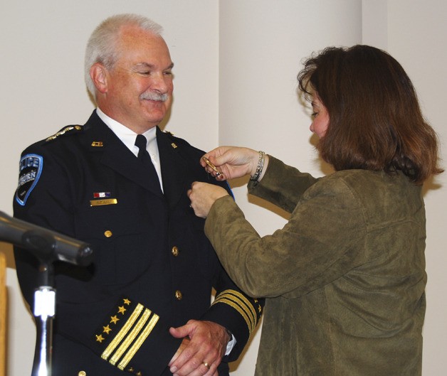 Auburn Police Chief Bob Lee receives a medal pin from wife Karin during his swearing-in ceremony at City Hall on Monday. Lee succeeds Jim Kelly