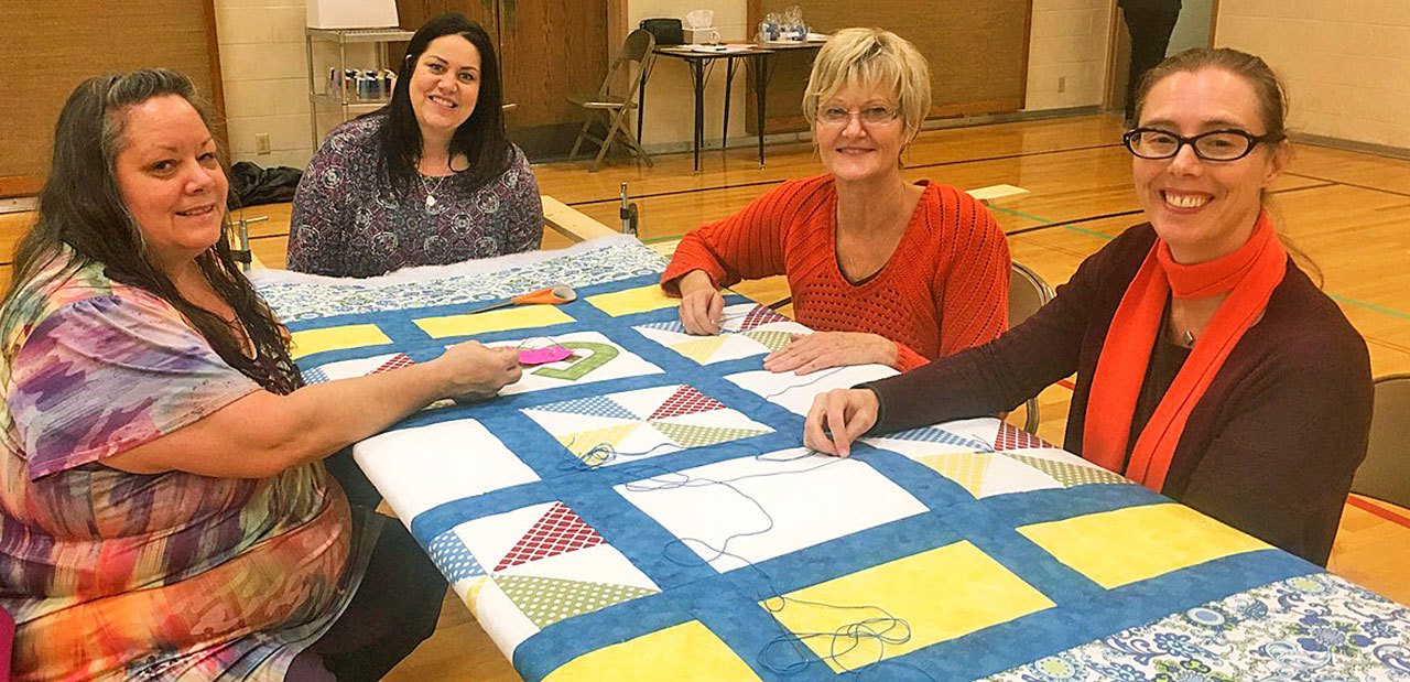 Job well done: Volunteers, from left, Dawn Merritt, Mindy Zuniga, Roma Farnsworth and Sara Harper are helping others with their quilting skills. COURTESY PHOTO