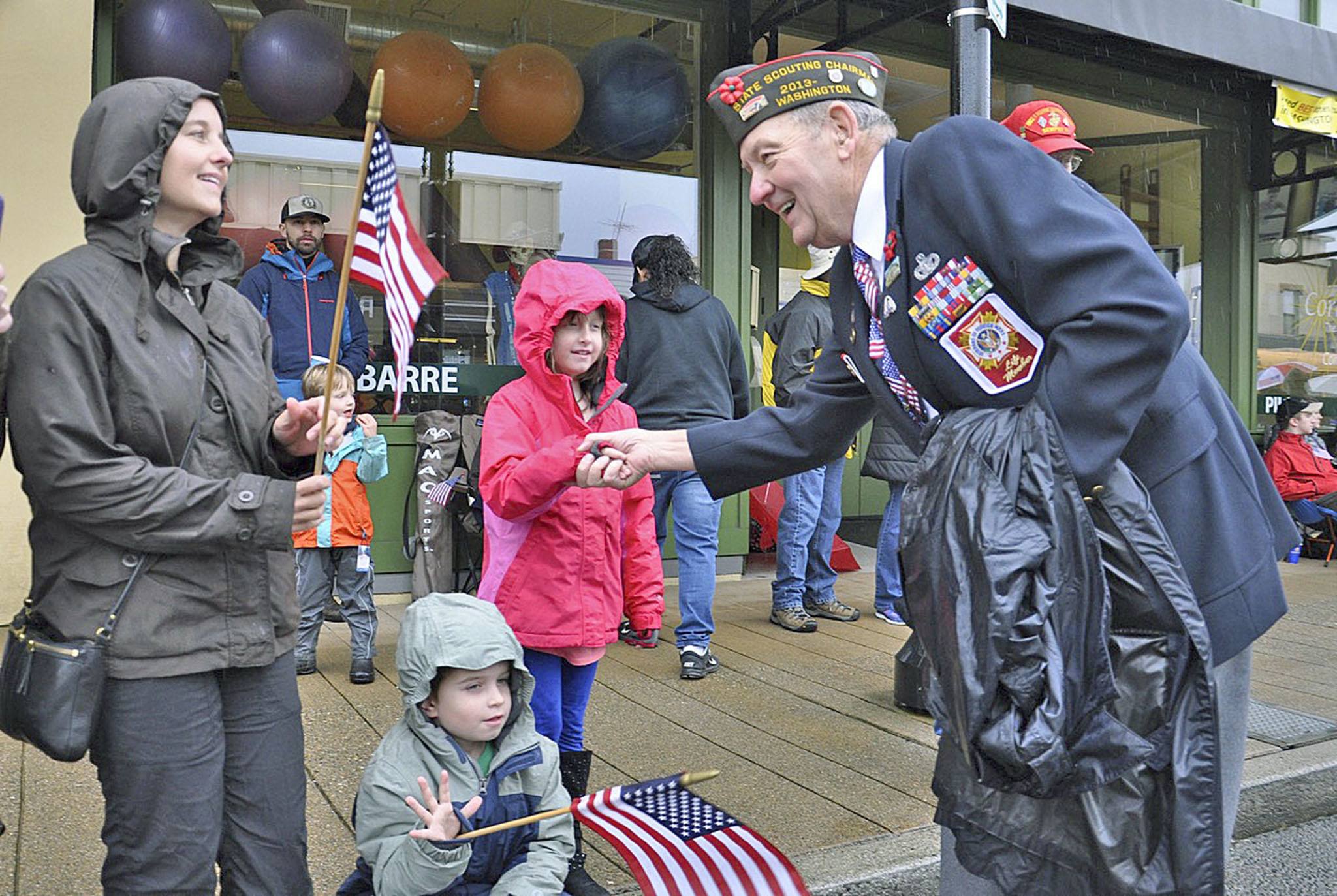 Veteran Joe Leister shakes hands with Holly Eusterman, 8, with her brother, Mikey, 6, and mom, Jennifer Eusterman, watching the parade on Saturday. RACHEL CIAMPI, Auburn Reporter