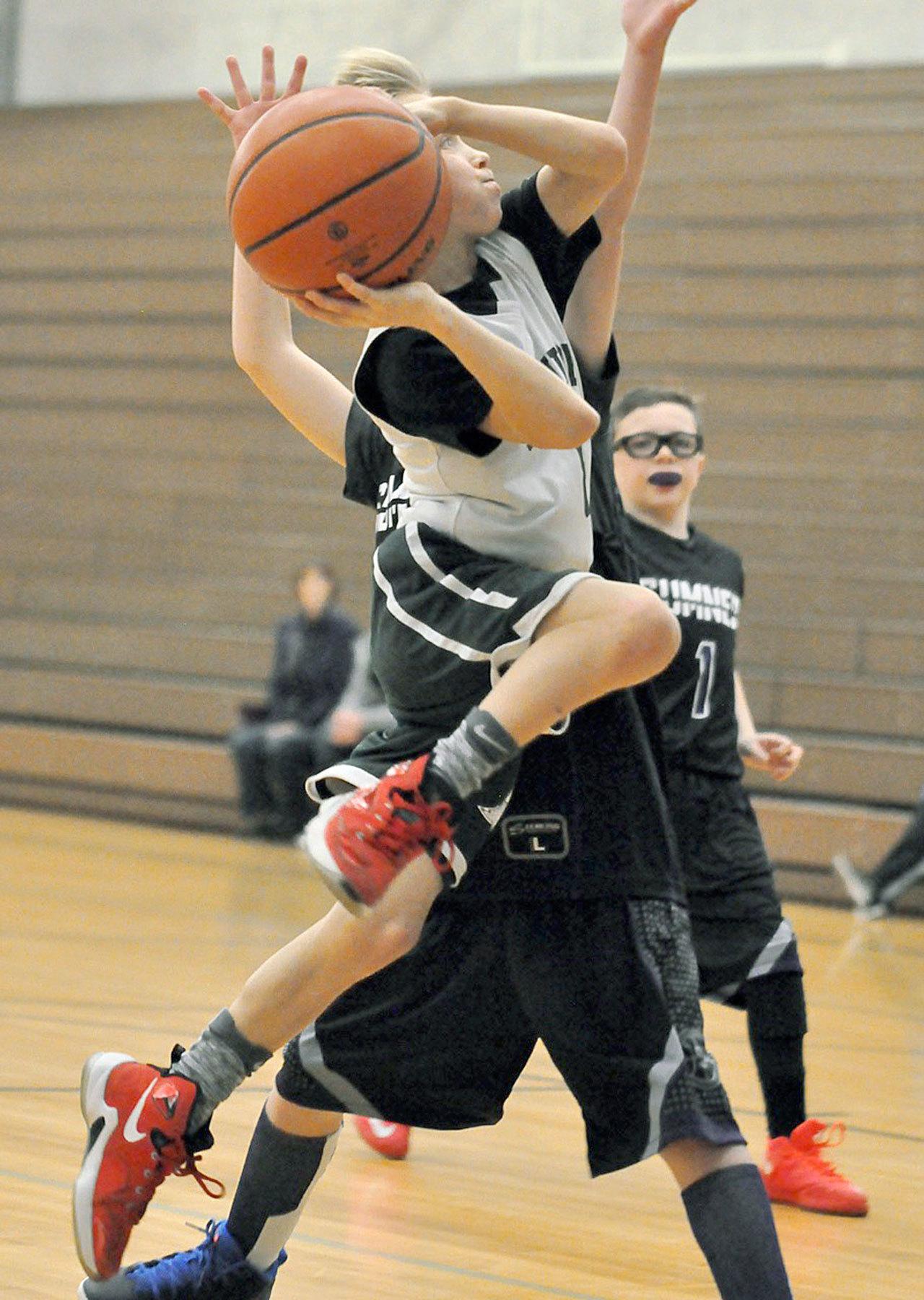 Carter Hansen of the fourth-grade ABA Green team drives to the basket against Sumner during Auburn Select Youth Basketball play at Olympic Middle School last Saturday. Teams of third- and fourth graders converged at the gym for action throughout the day. To learn more about the program, visit auburnhoops.com. RACHEL CIAMPI, Auburn Reporter