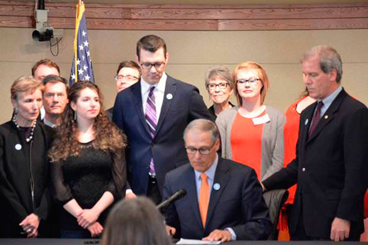 Gov. Jay Inslee signs into law a bill sponsored by Sen. Joe Fain increasing protections for victims of sexual assault. The event was held in the council chambers at Federal Way City Hall. COURTESY PHOTO